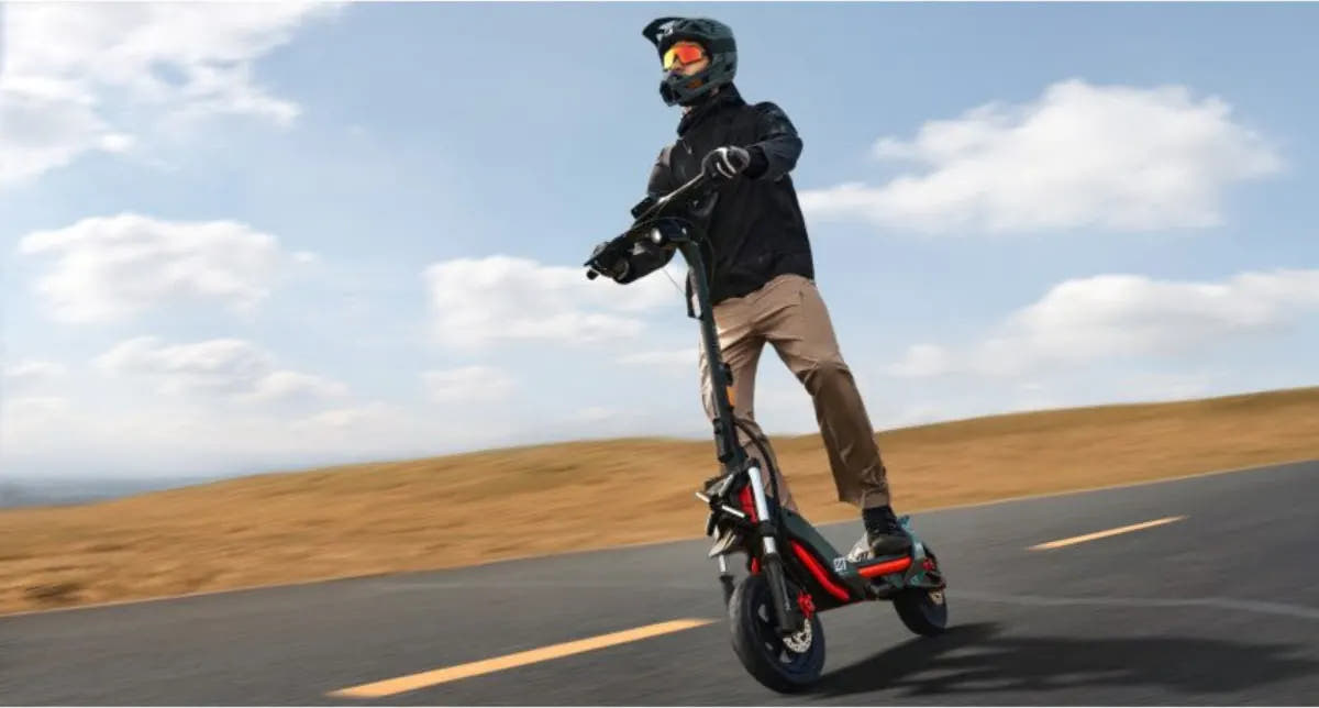 Un pilote casqué roule sur la Segway Ninebot ZT3 Pro sur une route de campagne
