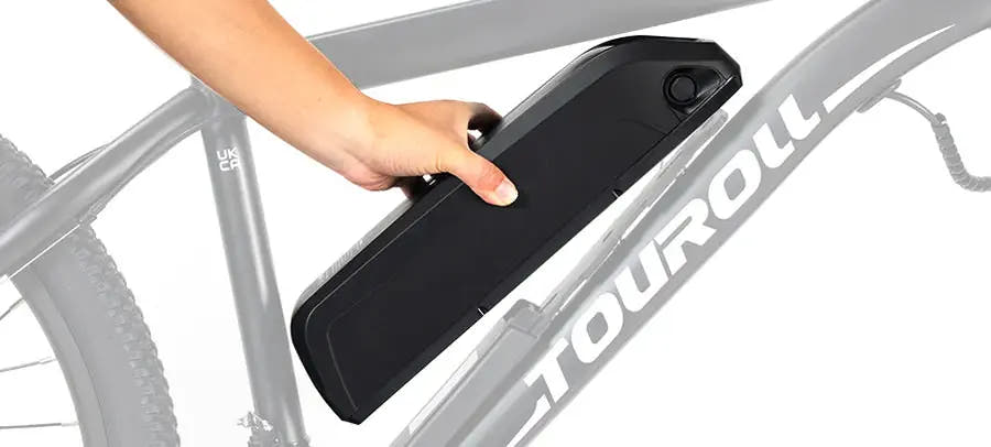 Une main retire la batterie Touroll de son logement le long du cadre